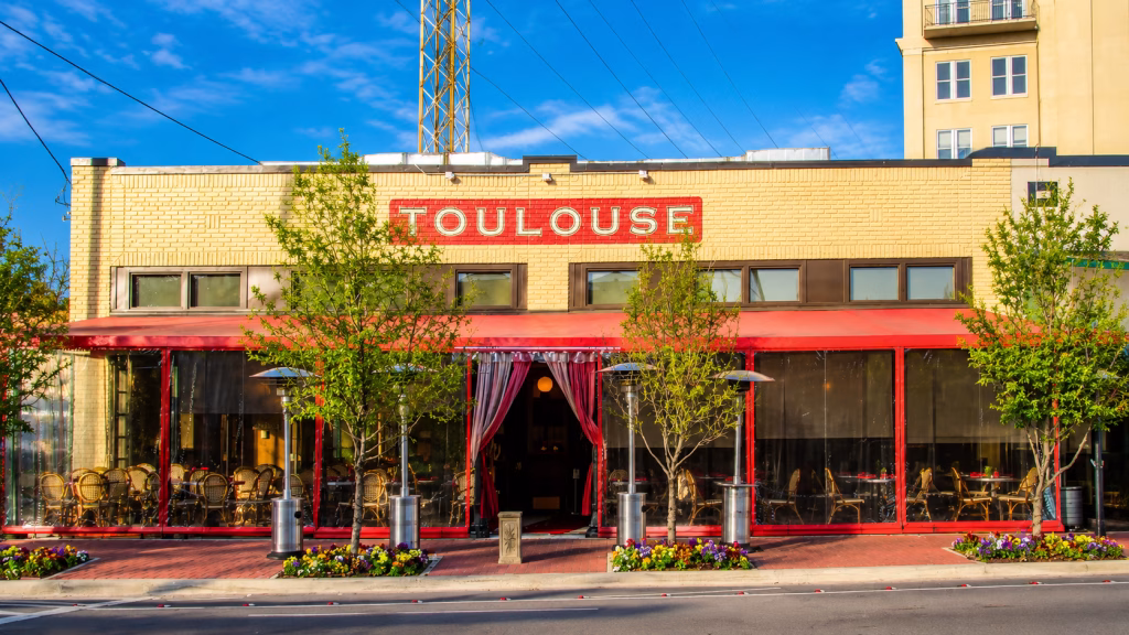 Outdoor patio and vibrant Parisian bistro dining room at Toulouse Café and Bar on Knox Street Dallas